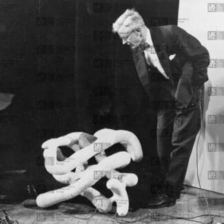 John Kendrew with large myoglobin sausage model with LMB logo watermark overlay.