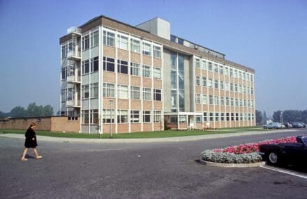 Exterior of building at a three-quarter angle with a woman walking in the foreground to the left of the building