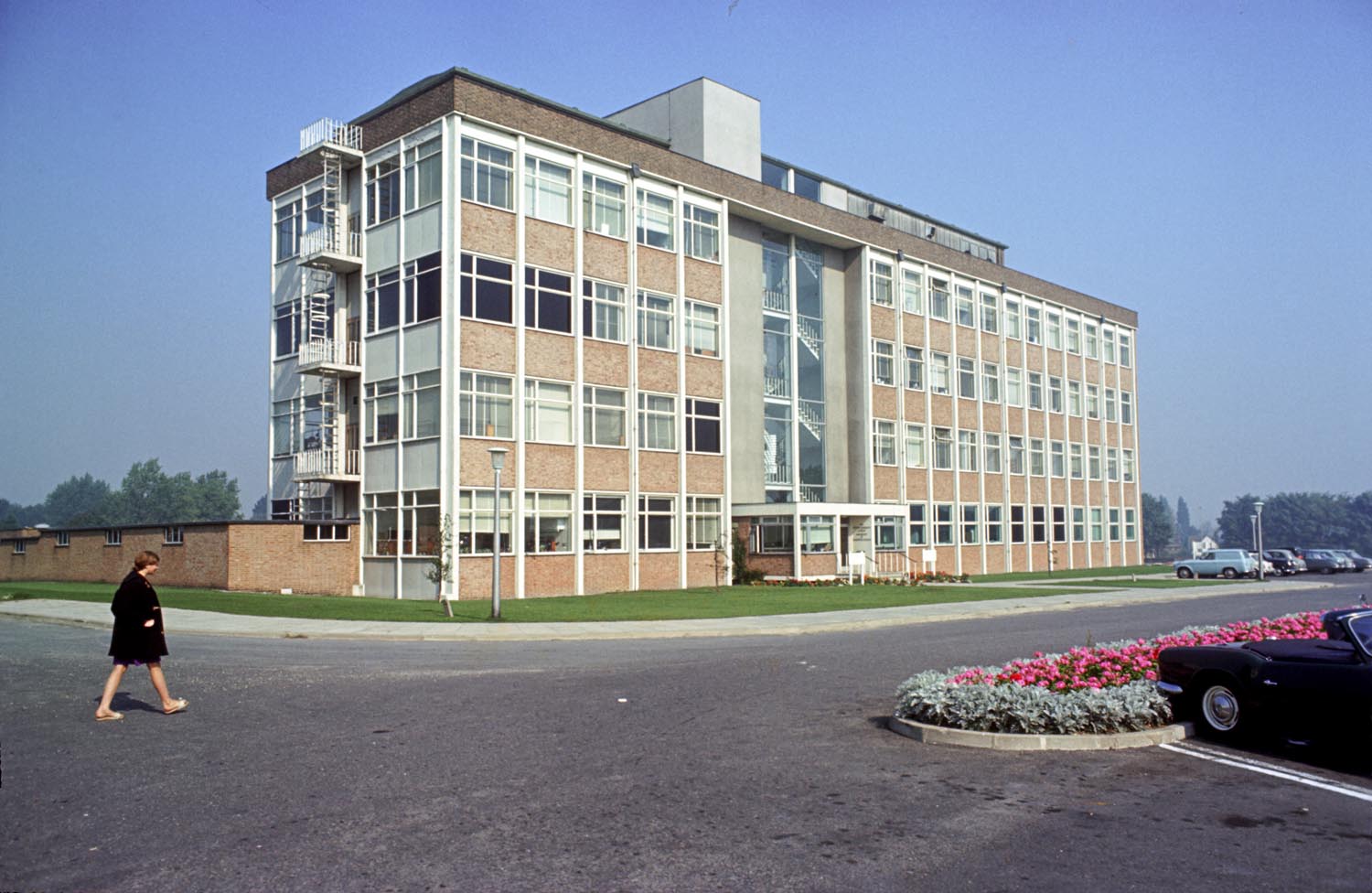 Exterior of building at a three-quarter angle with a woman walking in the foreground to the left of the building
