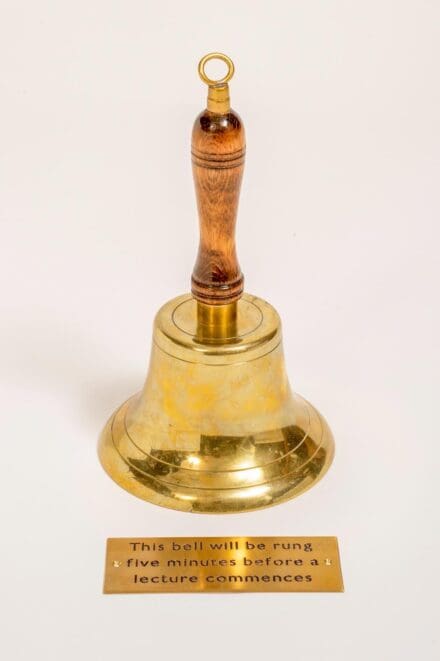 Gold metal bell with a gold plaque placed in front of it