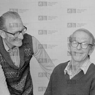 César Milstein and Fred Sanger with LMB logo watermark overlay.
