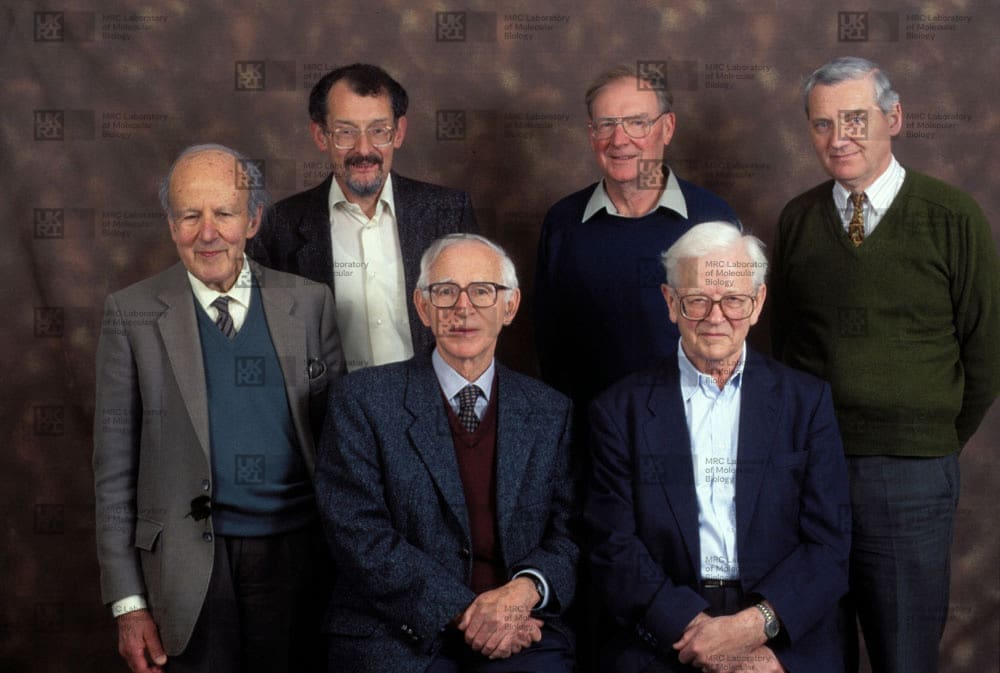 Group of scientists posing for a formal portrait with LMB logo watermark overlay.