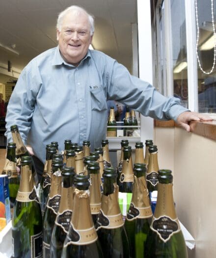 Mike Fuller stood behind a trolley of several empty champagne bottles
