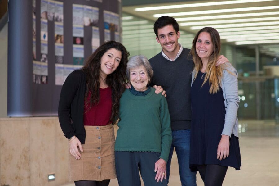 Group of four people stood closely together, smiling