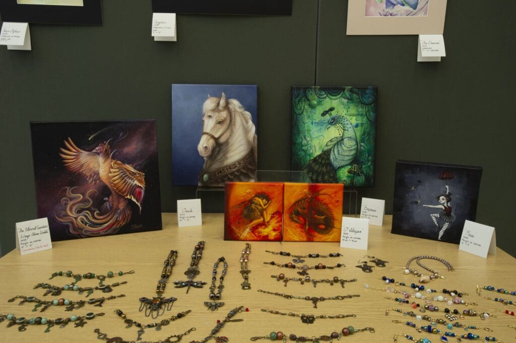 Table displaying jewellery and canvas paintings.