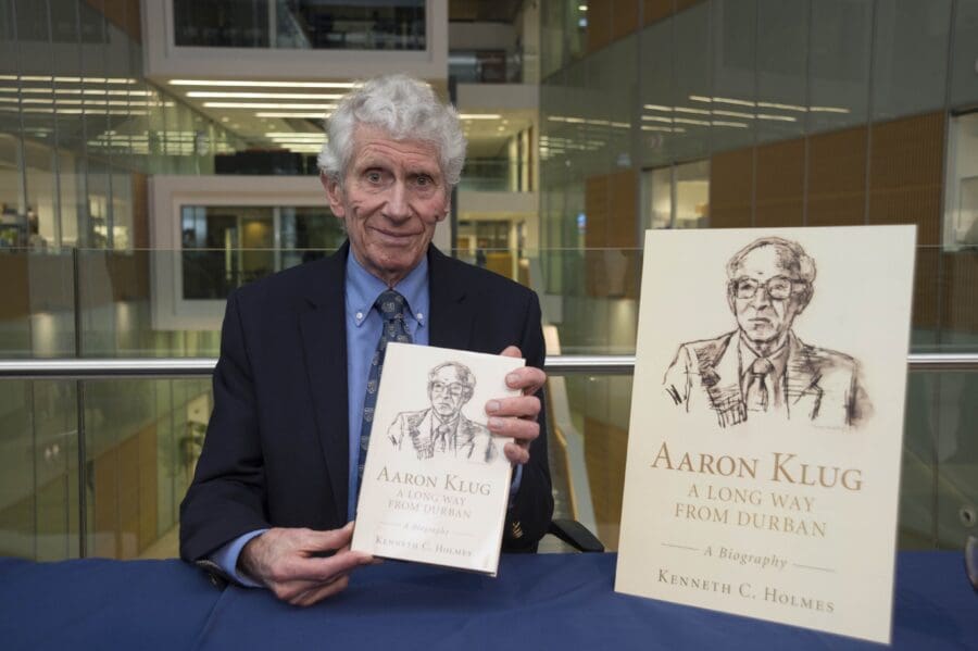 Ken Holmes holding a copy of 'Aaron Klug: A Long Way From Durban' book
