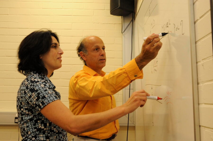 Cristina Rada and Michael Neuberger, both writing on a whiteboard