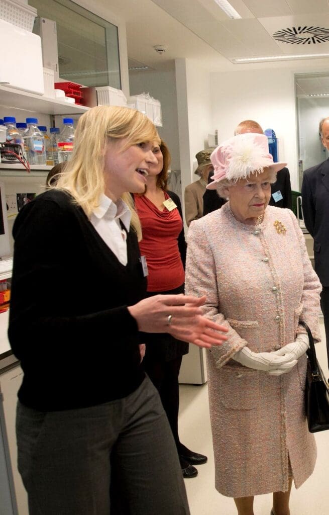 Woman speaking to Queen Elizabeth in lab space