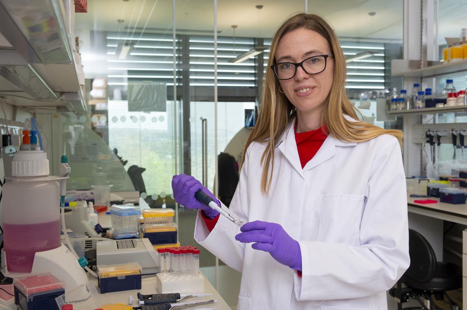 Madeline Lancaster in the lab, holding lab equipment.