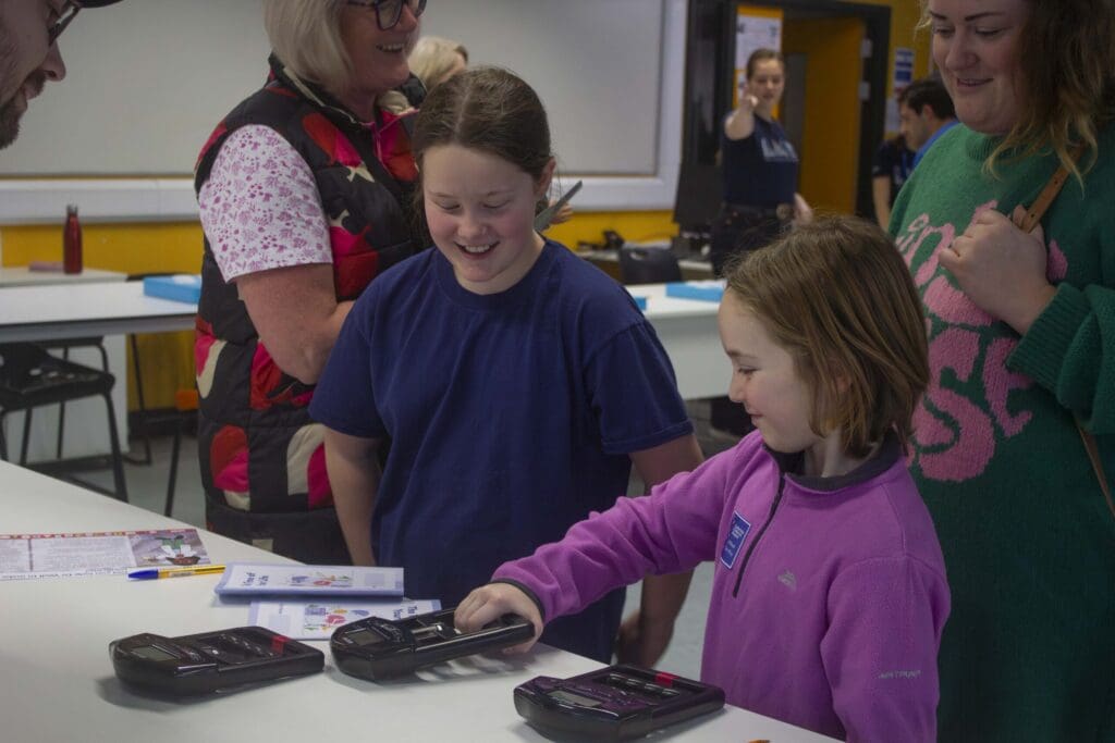 Group of adults and children at an interactive exhibit.