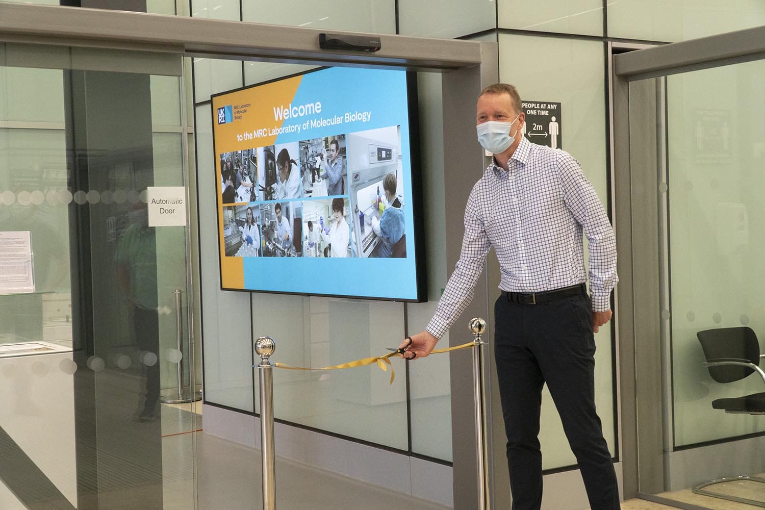 LMD Director Jan Löwe cutting the ribbon to officially open the new exhibition room.