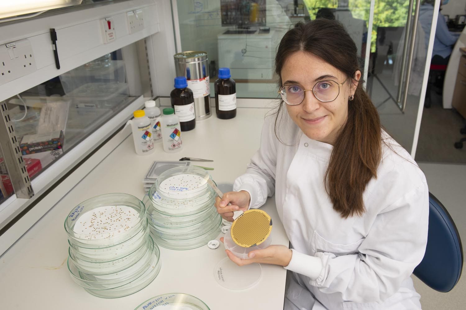 Researcher, Katerina Naydenova, holds a grid towards the camera which is round and golden.