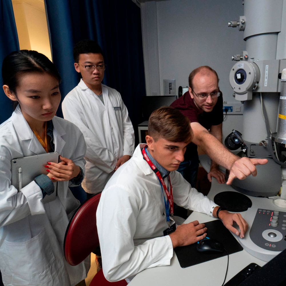 LIYSF students operating an electron microscope to look at virus particles