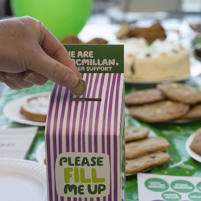 Donation being added to Macmillan collection box
