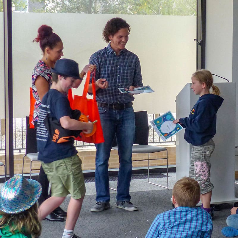 Children receiving certificates and books from Juan Rodriguez Molina